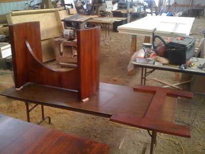 Conference table base being shaped and stained in the shop