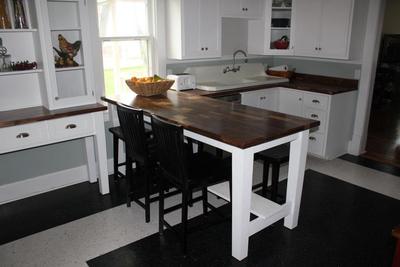 Dark-stained dining table and matching white kitchen island with a wood top