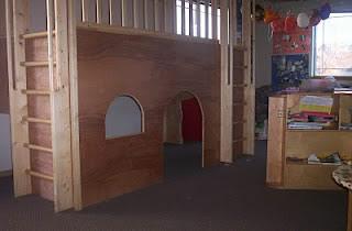 Indoor kids play loft with a ladder and window openings